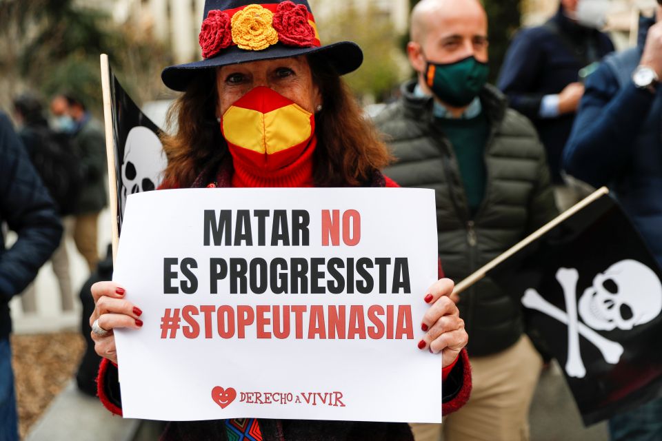 A woman protests against a law to legalize euthanasia as the Spanish Parliament votes to approve it in Madrid March 18, 2021. Her sign reads "Killing is not progressive, stop euthanasia." Increasing calls to legalize euthanasia in several European countri