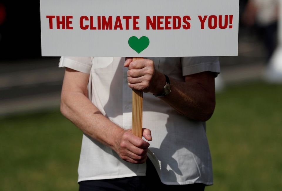 A protester from the Climate Coalition demonstrates in Parliament Square in London July 23. Catholics were among dozens of leaders from the major faiths in the United Kingdom who signed the Glasgow Multifaith Declaration ahead of the U.N. Climate Change C