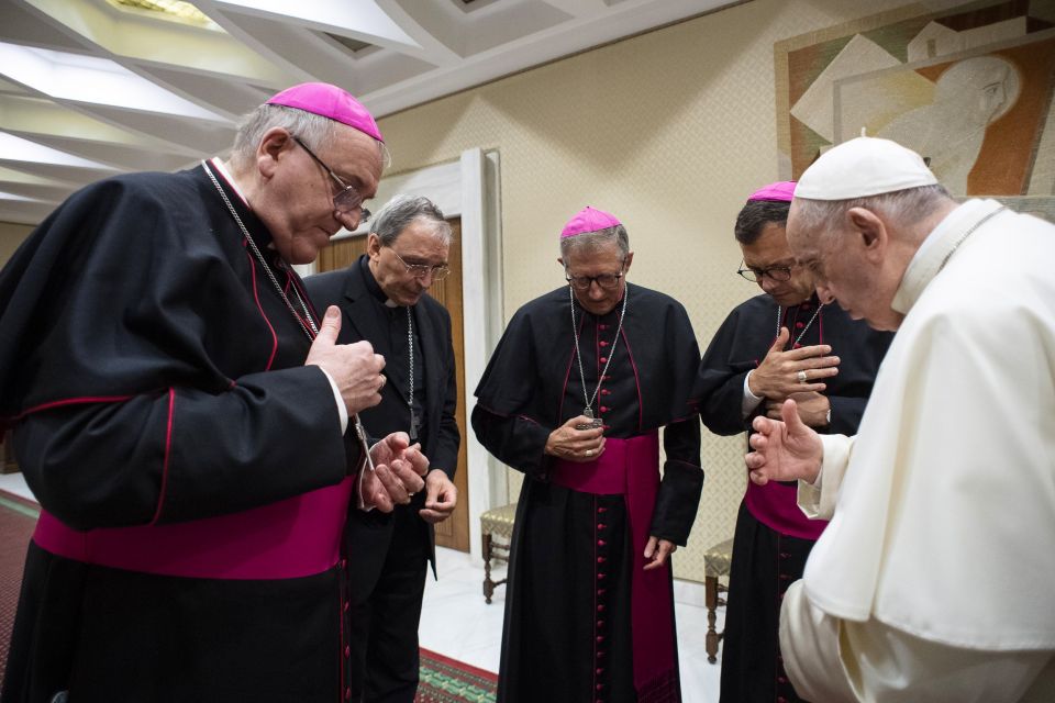 Pope Francis and four French bishops make the sign of the cross during silent prayer for the victims of abuses committed by members of the clergy, prior to the pope's general audience at the Vatican Oct. 6, 2021. The bishops were visiting Rome following a