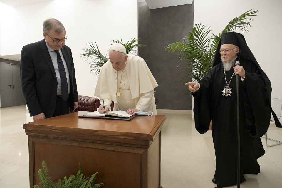 Pope Francis signs documents alongside Vincenzo Buonomo, rector of Rome's Pontifical Lateran University, and Ecumenical Patriarch Bartholomew of Constantinople, at the university Oct. 7, 2021. The event was to launch a new chair supported by UNESCO "On Fu