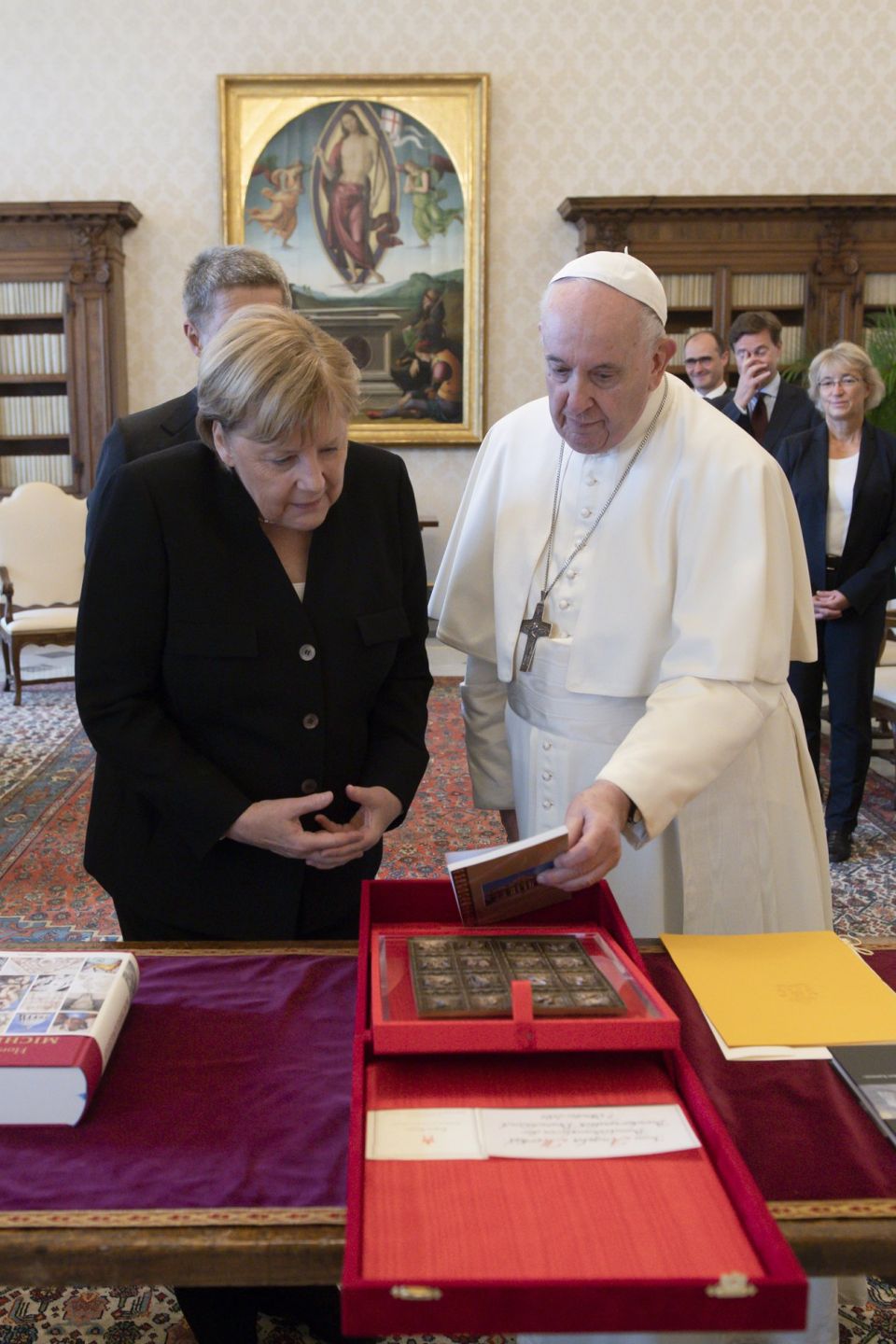 Pope Francis and German Chancellor Angela Merkel exchange gifts during a private meeting at the Vatican Oct. 7, 2021. (CNS photo/Vatican Media)