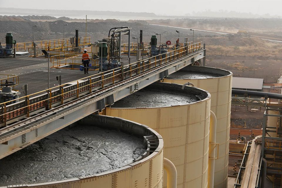 A worker walks atop tanks containing mud from which gold will be extracted at a gold mine site in Hounde, Burkina Faso, Feb. 13, 2020. The mine is operated by the U.K.-based Endeavour Mining Corporation. (CNS/Reuters/Anne Mimault)