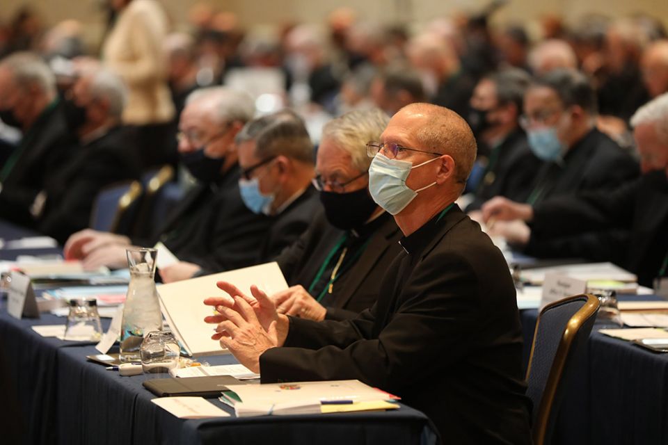 Seattle Archbishop Paul Etienne, wearing a protective mask, right, attends a Nov. 16 session of the fall general assembly of the U.S. Conference of Catholic Bishops in Baltimore. (CNS/Bob Roller)