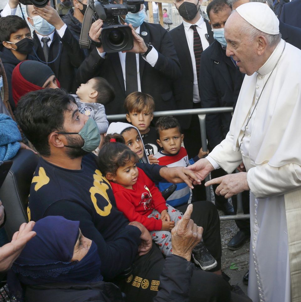 Pope Francis holds the hand of a man during a visit with refugees at the government-run Reception and Identification Center in Mytilene, Greece, Dec. 5, 2021. (CNS photo/Paul Haring)
