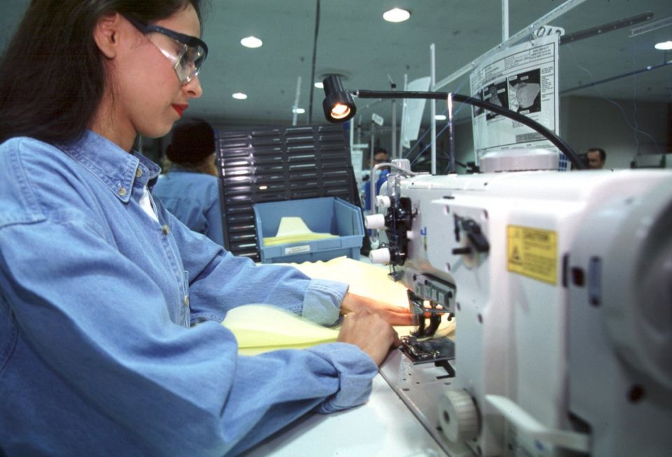 A worker sews air bags for Ford at Aguirre Safety Technologies in Detroit Aug. 12, 2004. (CNS photo/Jim West)