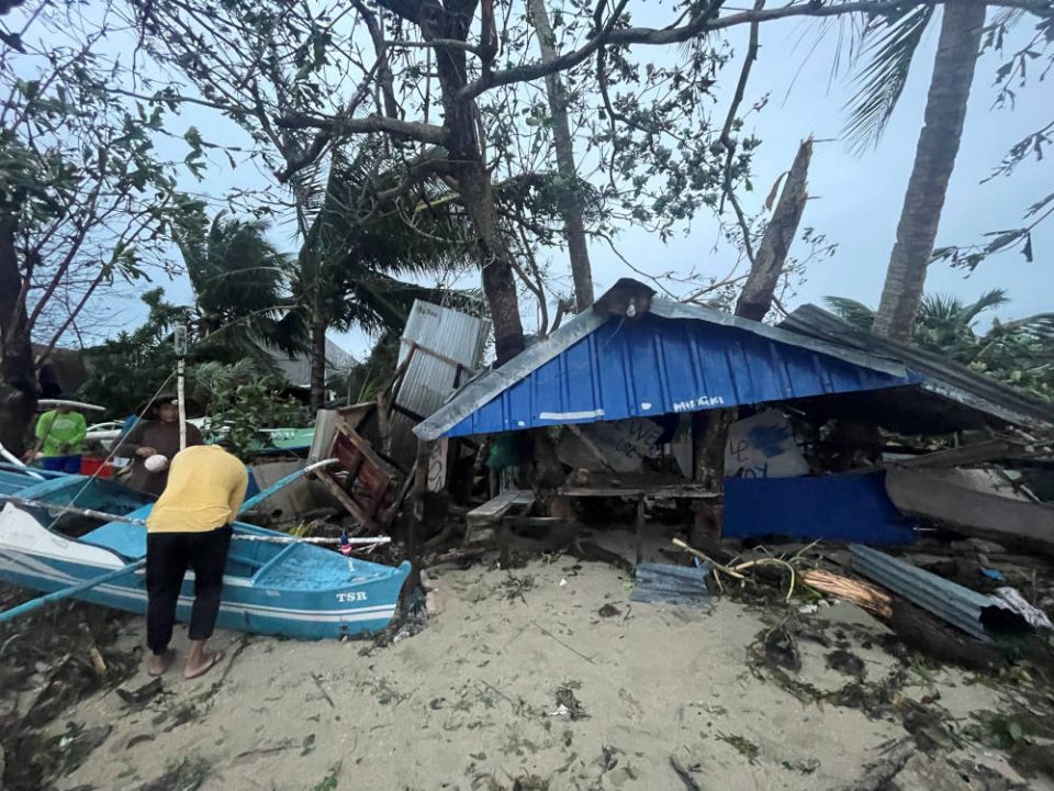 A man looks through debris in Dimiao, Philippines, Dec. 17, 2021, in the aftermath of Typhoon Rai. The storm has claimed at least 375 lives and Caritas Philippines has appealed for donations to bolster its emergency response. (CNS photo/via Reuters)
