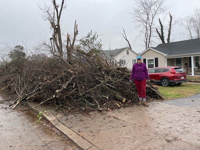 Anita "Annie" Adams of Bowling Green, Ky., stands next to the tornado debris pile in front of her house Dec. 18, 2021. (CNS photo/courtesy Jonathan Oglesby) 