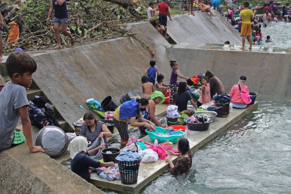 Residents clean their clothes near a river near Surigao City, Philippines, Dec. 18, 2021, in the aftermath of Typhoon Rai. The storm has claimed more than 370 lives. (CNS photo/Philippine Coast Guard handout via Reuters)