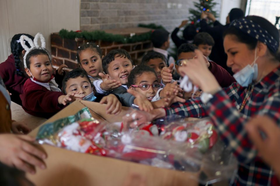 A teacher hands out to students Christmas-themed gifts at Rosary Sisters' School in Gaza City Nov. 24, 2021. (CNS photo/Mohammed Salem, Reuters)
