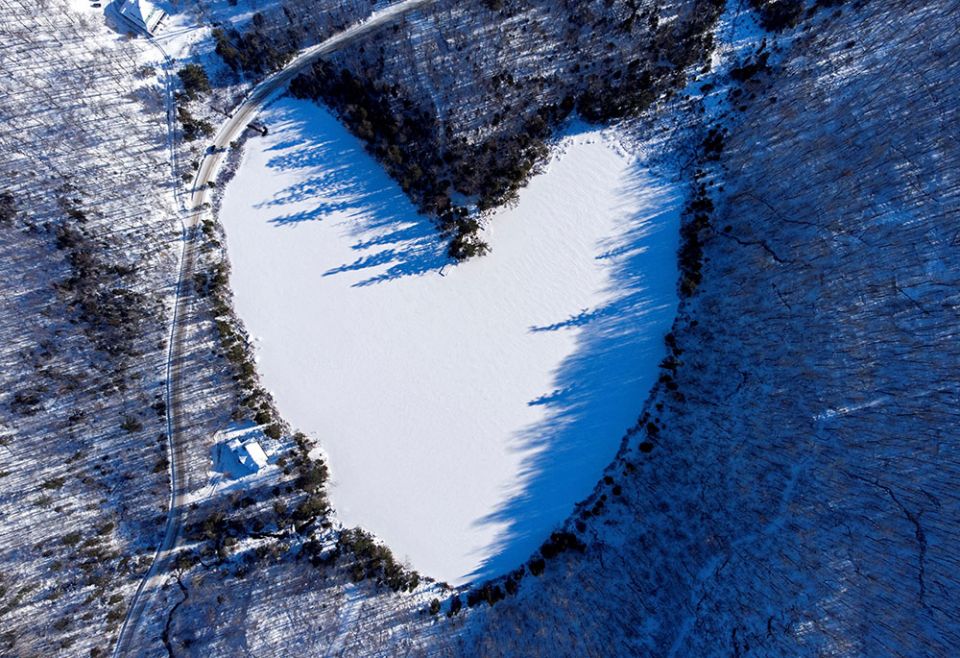 Snow in East Bolton, Quebec, covers the heart-shaped and frozen Baker Pond Dec. 24, 2021. (CNS/Reuters/Bernard Brault)