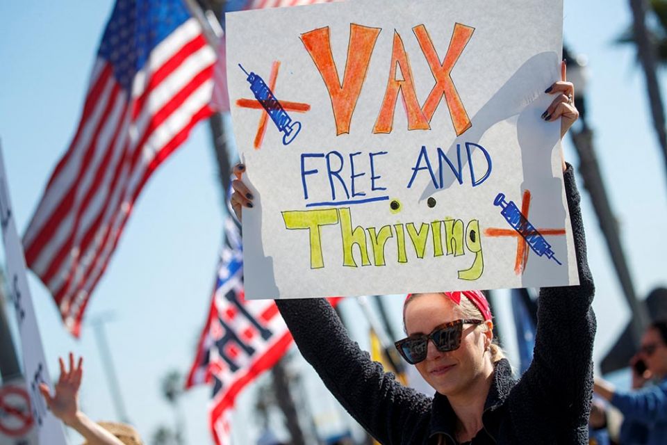 A woman in Huntington Beach, California, holds a sign during a protest about the COVID-19 vaccine mandates for school children and workers Jan. 3. (CNS/Reuters/Mike Blake)