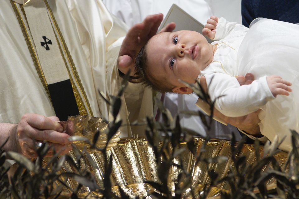 Pope Francis baptizes a baby as he celebrates Mass marking the feast of the Baptism of the Lord in the Sistine Chapel at the Vatican Jan. 9, 2022. (CNS photo/Vatican Media)