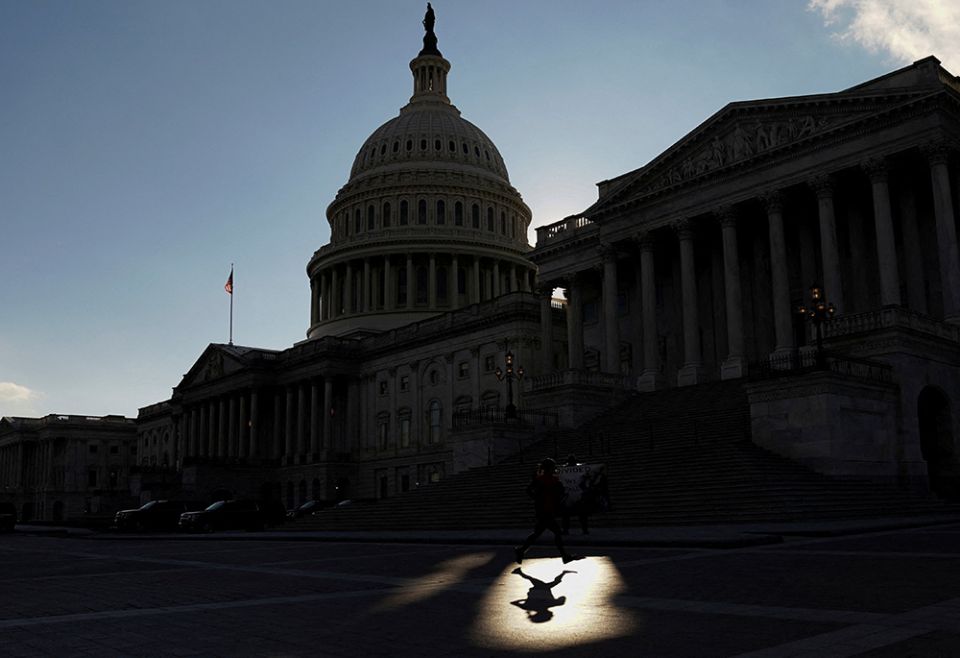 A jogger passes through a beam of sunlight in front of the U.S Capitol Jan. 18 in Washington. (CNS/Reuters/Kevin Lamarque)