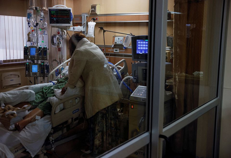 The mother of a COVID-19 patient stands at the bedside of the patient in the intensive care unit of the St. Mary Medical Center Feb. 1 in Apple Valley, California. (CNS/Reuters/Shannon Stapleton)