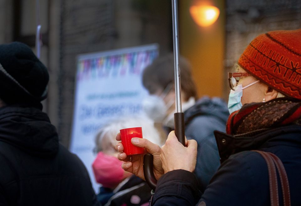 A woman holds a candle during a rally for victims of clerical sexual abuse, Jan. 21 in front of the cathedral in Essen, Germany. (CNS/KNA/Andre Zelck)