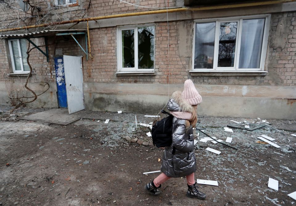 A girl walks past an apartment building damaged by recent shelling in Donetsk, Ukraine, Feb. 24, 2022, after Russian President Vladimir Putin authorized a military operation in Ukraine. (CNS photo/Alexander Ermochenko, Reuters)