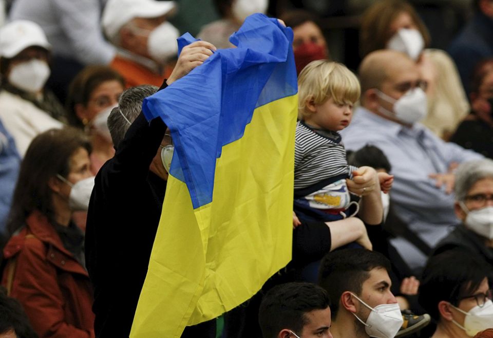 A man holds Ukraine's flag as Pope Francis leads his general audience in the Paul VI Hall March 2 at the Vatican. (CNS/Paul Haring)