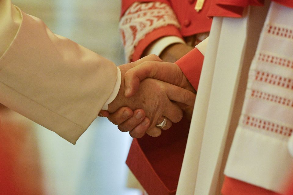 Pope Francis shakes hands with a cardinal during an "ordinary public consistory" for the approval of the canonizations of 10 new saints, at the Vatican March 4, 2022. (CNS photo/Vatican Media)