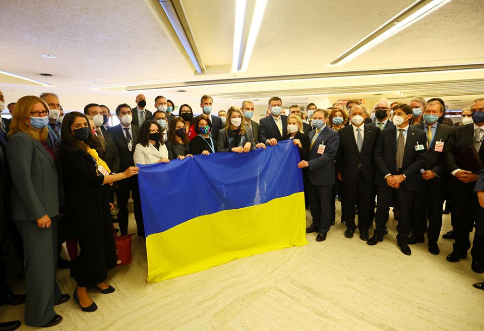 Mélanie Joly, Yevheniia Filipenko, Ukraine's permanent U.N. representative, and other delegates gather with a Ukrainian flag after walking out of the U.N. Human Rights Council meeting during a Russian video speech March 1 in Geneva. (CNS) Mélanie Joly, Yevheniia Filipenko, Ukraine's permanent U.N. representative, and other delegates gather with a Ukrainian flag after walking out of the U.N. Human Rights Council meeting during a Russian video speech March 1 in Geneva. (CNS)