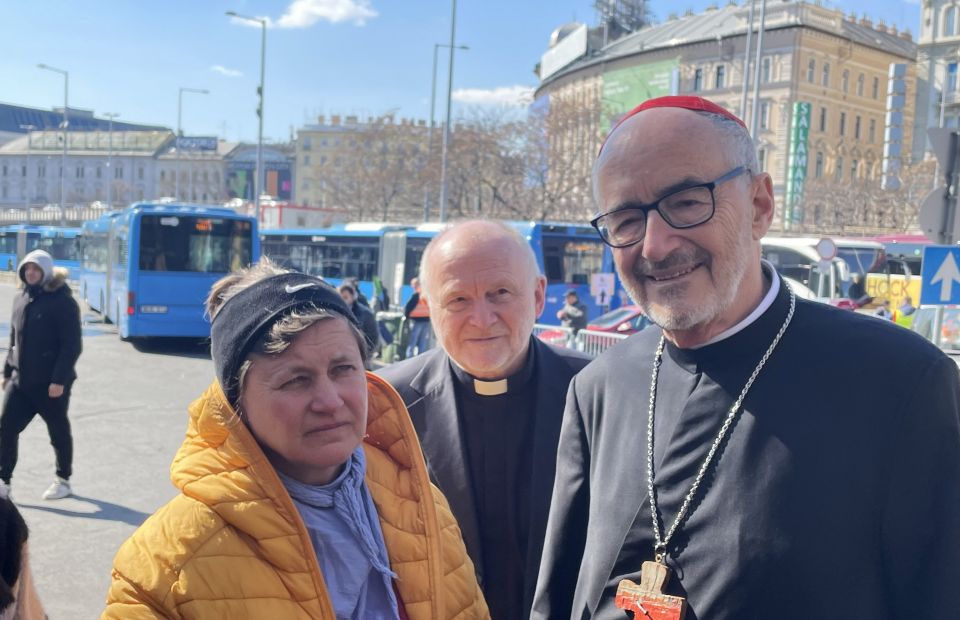 Cardinal Michael Czerny, interim president of the Dicastery for Promoting Integral Human Development, and Jesuit Father Sajgó Szabolcs from Jesuit Refugee Service, speak to a refugee who fled Odessa, Ukraine, and arrived at the Nyugati train station in Bu