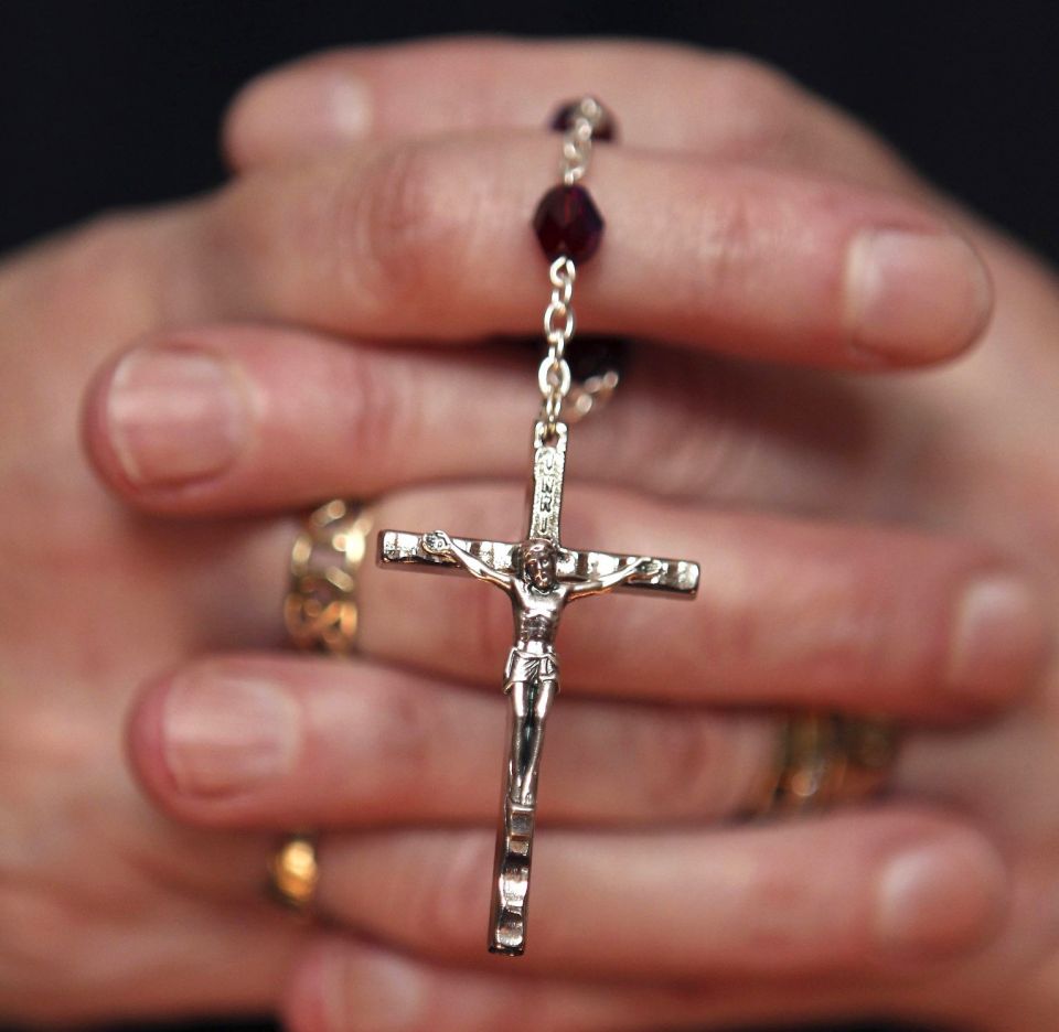 A woman holds rosary during Mass at a church in Armagh, Northern Ireland, March 21, 2010. (CNS photo/Cathal McNaughton, Reuters)