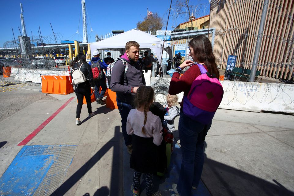 A Ukrainian family waits for a humanitarian visa outside the San Ysidro Port of Entry at the U.S.-Mexico border in Tijuana, Mexico March 11, 2022. (CNS photo/Jorge Duenes, Reuters)