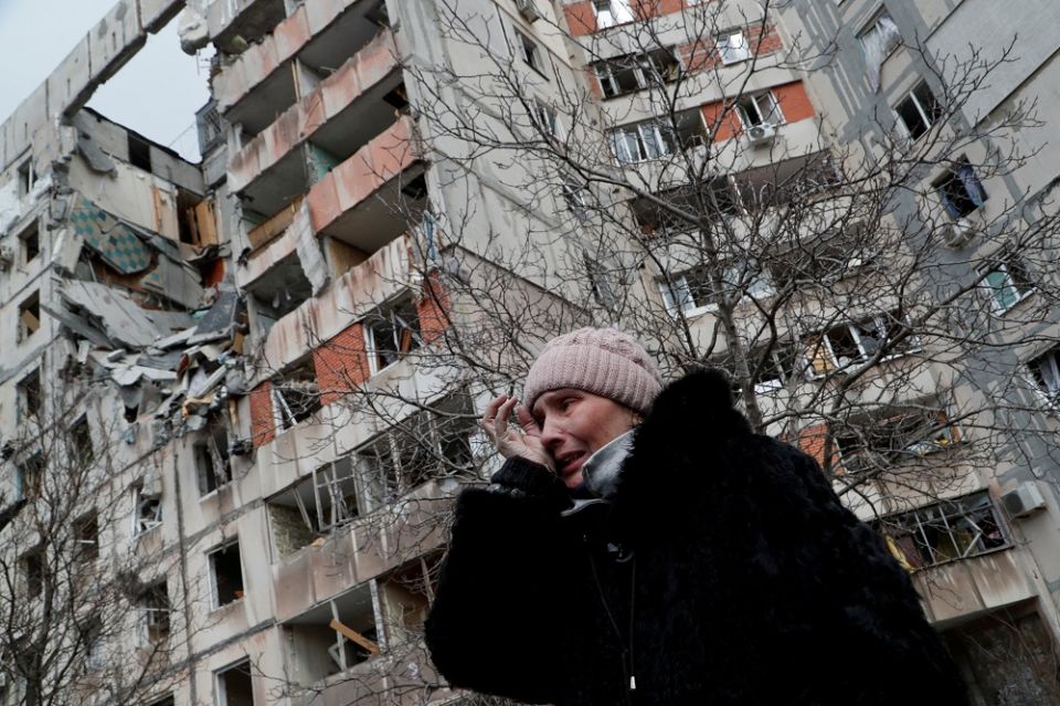 A woman reacts in front of destroyed apartment buildings in Mariupol, Ukraine, March 17, 2022.