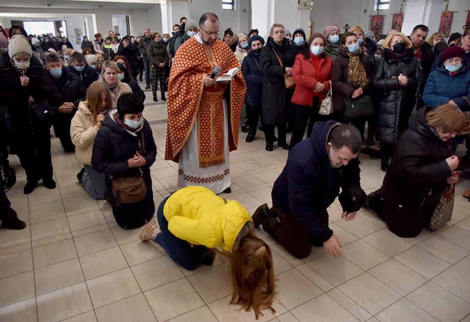 People pray for peace in Ukraine in front of the replica of the original statue of Our Lady of Fatima in the Church of the Nativity of the Blessed Virgin in Lviv, Ukraine, March 18, amid Russia's invasion of the country. (CNS/Reuters/Pavlo Palamarchuk)