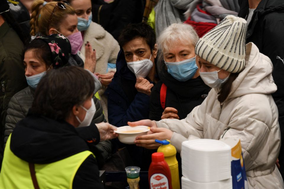 A volunteer hands a bowl of soup to a woman fleeing the Russian war in Ukraine at Berlin's central station March 9, 2022. (CNS photo/Annegret Hilse, Reuters)