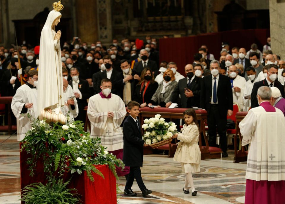 Children carry flowers to place at a Marian statue after Pope Francis consecrated the world and, in particular, Ukraine and Russia to the Immaculate Heart of Mary during a Lenten penance service in St. Peter's Basilica at the Vatican. (CNS/Paul Haring)