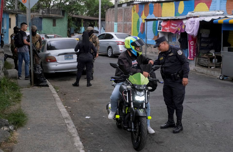 A Salvadoran police officer searches a man at a checkpoint in San Salvador March 30, 2022. (CNS photo/Jose Cabezas, Reuters)