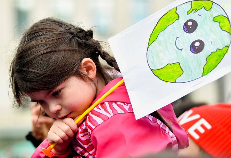 A child in Glasgow, Scotland, holds a placard at a "Fridays for Future" march Nov. 5, 2021, during the U.N. Climate Change Conference. (CNS/Reuters/Dylan Martinez)