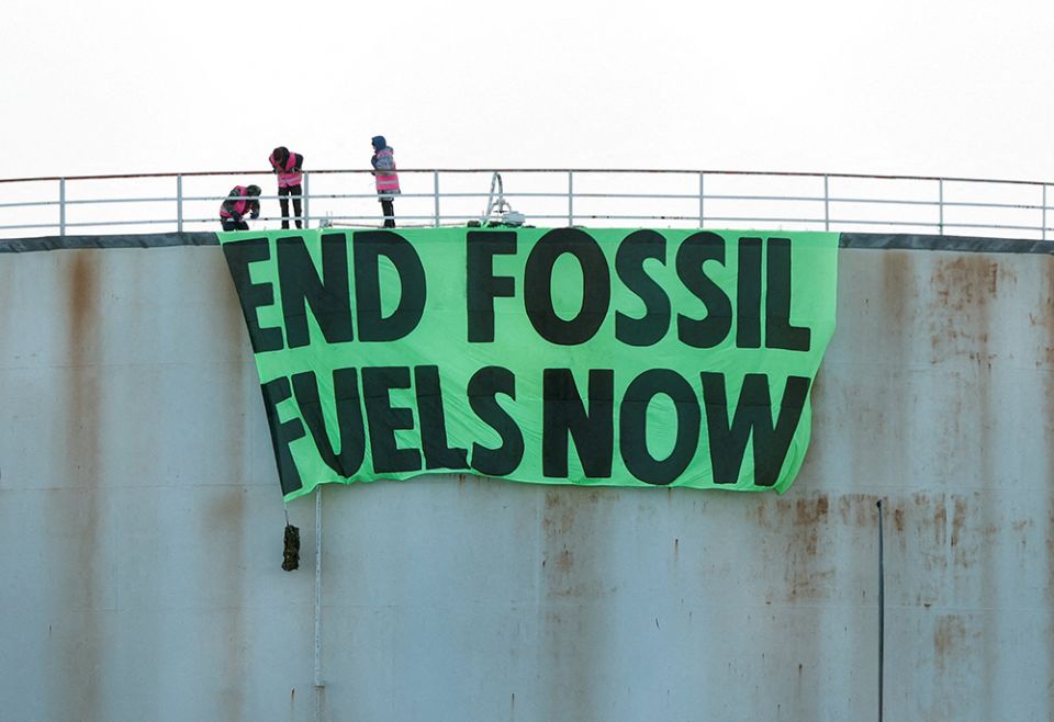 Activists at Esso West London Terminal in Staines, England, hang a sign on a storage tank April 1. (CNS/Reuters/John Sibley) Activists at Esso West London Terminal in Staines, England, hang a sign on a storage tank April 1. (CNS/Reuters/John Sibley)