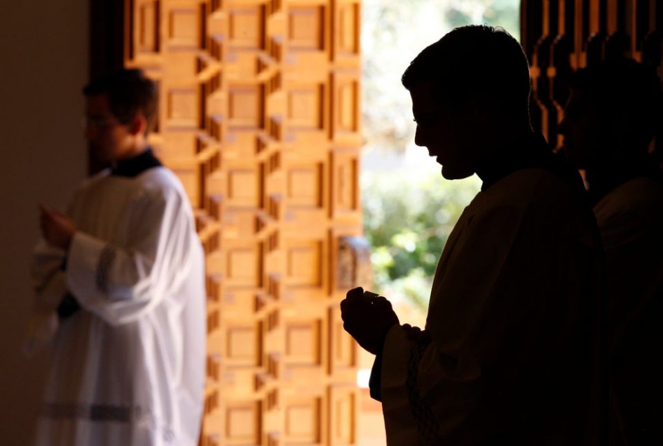A Legionaries of Christ seminarian is silhouetted as he attends a Mass in the chapel of Regina Apostolorum University in Rome in this June 7, 2013. (CNS/Paul Haring)