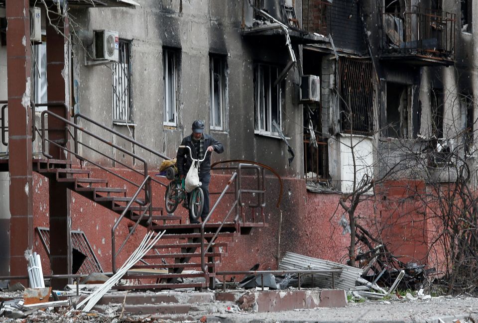 A man walks down the stairs outside a residential building damaged by Russian shelling in Mariupol, Ukraine, April 21, 2022. (CNS photo/Alexander Ermochenko, Reuters)