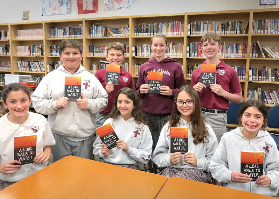 Seventh graders at Our Lady of Lourdes School in Slidell, La., pose for a photo with the book "A Long Walk to Water," a nonfiction novel by Linda Sue Park. (CNS/Clarion Herald/Beth Donze)
