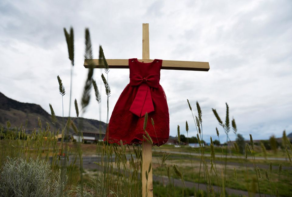 A child's red dress hangs on a cross near the grounds of the former Kamloops Indian Residential School in Kamloops, British Columbia, June 6, 2021. (CNS/Reuters/Jennifer Gauthier)
