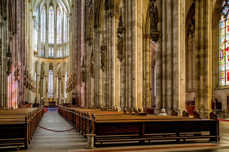 A woman prays in a pew at a nearly empty cathedral in Cologne, Germany, March 16, 2020. (CNS/KNA/Theodor Barth)