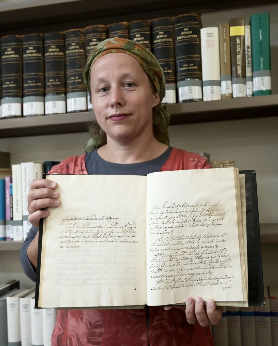 Pnina Younger, archivist at Central Archives for the History of the Jewish People at the Israel National Library, holds a rare 18th-century manuscript with details of the Portuguese Inquisition in Jerusalem July 19, 2022. (CNS photo/Debbie Hill)