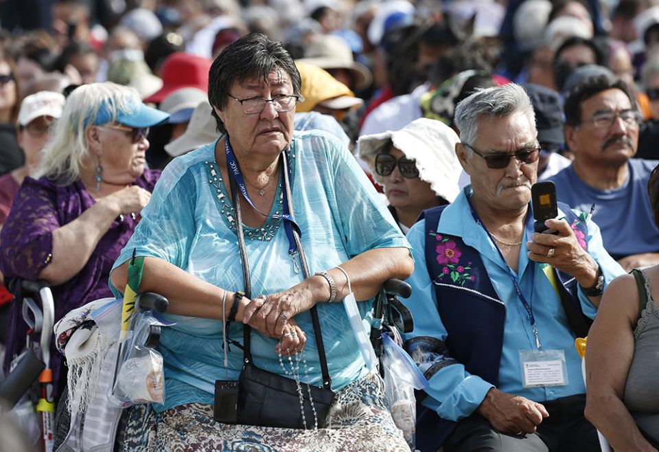 A woman holds a rosary as people wait for the start of Pope Francis' celebration of Mass at Commonwealth Stadium July 26 in Edmonton, Alberta. (CNS/Paul Haring) A woman holds a rosary as people wait for the start of Pope Francis' celebration of Mass at Commonwealth Stadium July 26 in Edmonton, Alberta. (CNS/Paul Haring)