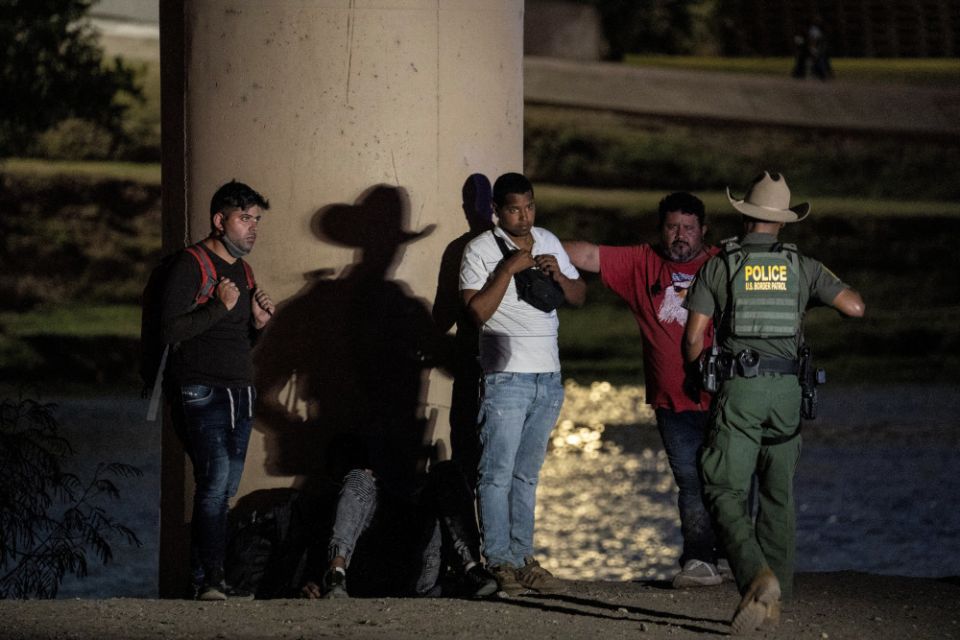 Migrants in Eagle Pass, Texas, wait to be transported by U.S. Customs and Border Protection agents after crossing the Rio Grande July 26, 2022.
