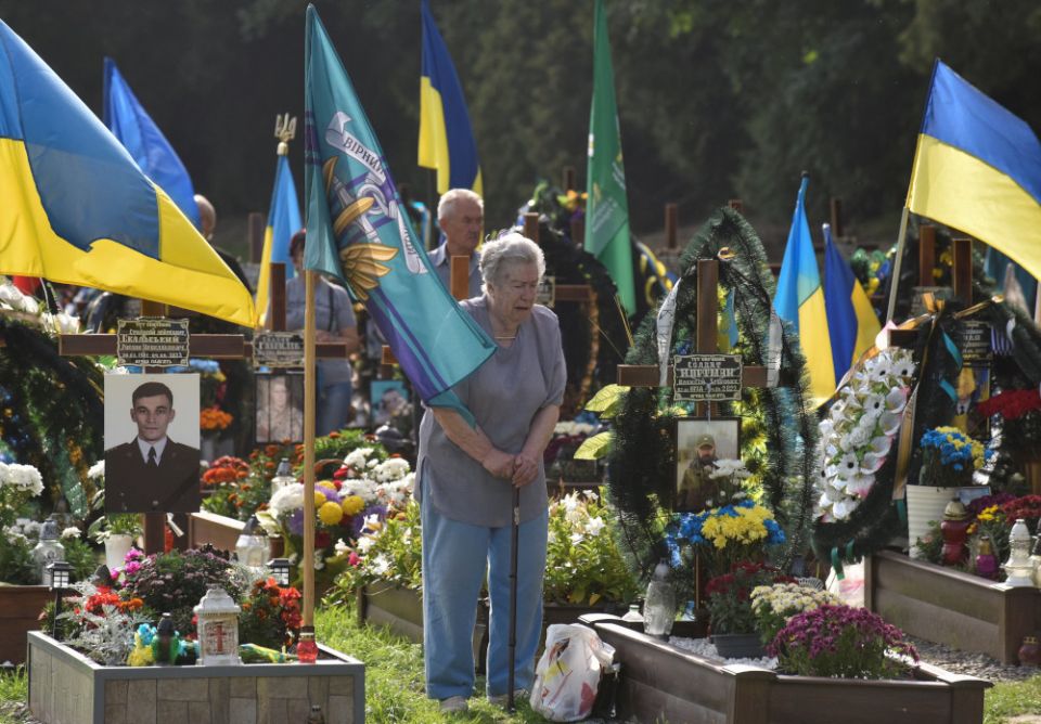 A woman mourns as she visits the tomb of her relative on Independence Day in Lviv, Ukraine, Aug. 24, 2022.