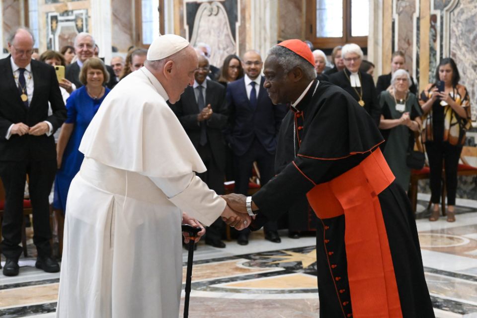 Pope Francis greets Cardinal Peter Turkson, chancellor of the Pontifical Academy of Sciences and the Pontifical Academy of Social Sciences, during an audience with members of the Pontifical Academy of Sciences at the Vatican Sept. 10, 2022. 
