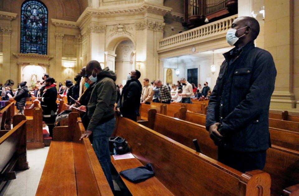Paul Ndong, right, joins dozens of parishioners for a French Mass at the Church of Notre Dame in New York, on Sunday, March 6. Many parishioners come from former French and Belgium colonies in Africa, like Senegal, Ivory Coast, Mali and Togo.