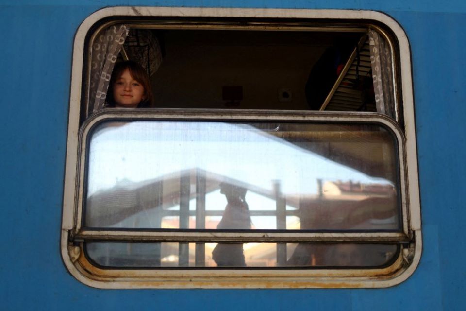 A Ukrainian girl from Kharkiv, Ukraine, looks out a train window bound for Warsaw, Poland, March 23 with people fleeing Russia's ongoing war in Ukraine. (CNS photo/Hannah McKay, Reuters)