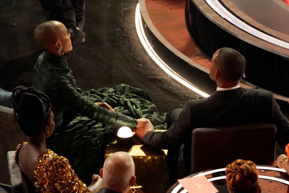 Jada Pinkett Smith, left, and Will Smith hold hands in the audience at the Oscars on March 27. The stunning physical altercation between Will Smith and Chris Rock has sparked debate about the appropriate ways for Black men to publicly defend Black women. 