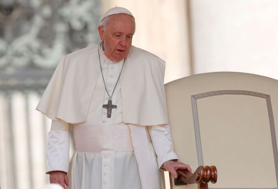 Pope Francis holds onto the arm of his chair as he arrives for the general audience in St. Peter's Square at the Vatican April 20. Since February, the pope, who has long suffered from sciatica, has repeatedly had difficulty walking, resulting in a number