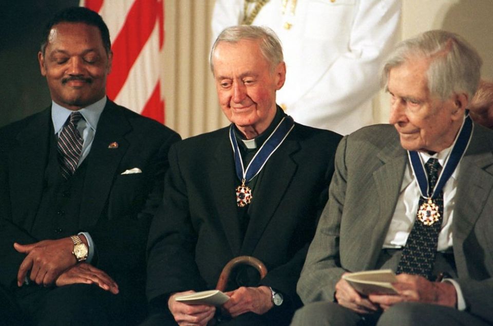 Msgr. George Higgins, center, smiles after receiving the nation's highest civilian honor, the Presidential Medal of Freedom, from President Bill Clinton in 2000. He was recognized for his lifelong commitment to workers' rights. (CNS)