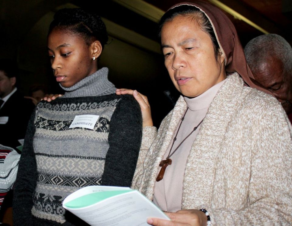 A religious sister places her hand on the shoulder of a candidate during the Rite of Election and Call to Continuing Conversion ceremony in the Diocese of Brooklyn in the 2016 file photo. (CNS/The Tablet/Marie Elena Giossi)