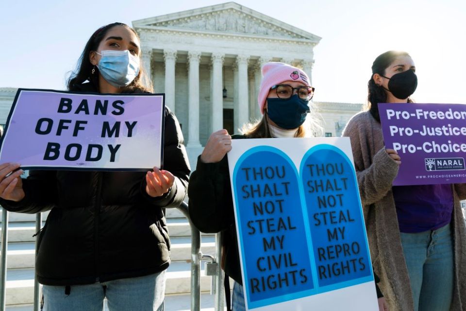 Caroline McDonald, left, a student at Georgetown University; Lauren Morrissey, with Catholics for Choice; and Pamela Huber, of Washington, join an abortion-rights rally outside the Supreme Court, Nov. 1, 2021, as arguments are set to begin about abortion.